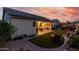 Secluded backyard with synthetic grass, patio seating, BBQ, desert landscaping, and colorful sky at dusk at 17812 W Primrose W Ln, Surprise, AZ 85374