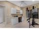 Bright room with a ceiling fan, built-in desk, and an exercise bike, offering space for work and fitness at 17812 W Primrose W Ln, Surprise, AZ 85374