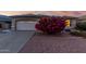 Charming single-story home boasts a two-car garage and a vibrant flowering bush in the front yard at 17812 W Primrose W Ln, Surprise, AZ 85374