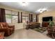 Bright living room with tile flooring, warm walls, and views of the backyard at 17812 W Primrose W Ln, Surprise, AZ 85374