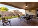 Covered patio features a stone water feature and outdoor dining set with wrought iron chairs at 17812 W Primrose W Ln, Surprise, AZ 85374