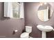 Charming powder room featuring a pedestal sink, decorative mirror, and window with curtain at 21182 E Stonecrest Dr, Queen Creek, AZ 85142