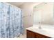 Well-lit bathroom with a single sink vanity and seashell-themed shower curtain and tile flooring at 21182 E Stonecrest Dr, Queen Creek, AZ 85142