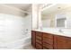 Bathroom with double sinks, wood cabinets, shower-tub, and decorative lighting at 21182 E Stonecrest Dr, Queen Creek, AZ 85142