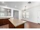 Open concept kitchen and dining area with wood floors and granite-topped island at 21182 E Stonecrest Dr, Queen Creek, AZ 85142
