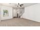 Spacious living room with neutral carpet, white walls, and a staircase leading to the upper level at 21182 E Stonecrest Dr, Queen Creek, AZ 85142