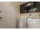 Bright laundry room features a side-by-side washer and dryer, overhead cabinets, and door at 215 N Power Rd # 21, Mesa, AZ 85205