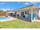 Charming backyard featuring a covered patio, sparkling pool, and lush lawn, ideal for relaxing and entertaining at 2207 W Bentrup St, Chandler, AZ 85224
