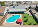 Aerial view of pool with lounge chairs, green lawn, covered patio, and fence at 2207 W Bentrup St, Chandler, AZ 85224