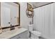 Updated bathroom features a vanity, toilet, shower with curtain, and a mirror with a wooden frame at 2207 W Bentrup St, Chandler, AZ 85224