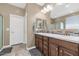 Bathroom featuring dual sinks, a mosaic backsplash, wood cabinets and tile flooring at 22353 N 99Th Ln, Peoria, AZ 85383