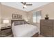 Cozy bedroom featuring a queen bed, wood furniture, a ceiling fan, and a sunlit window at 22353 N 99Th Ln, Peoria, AZ 85383