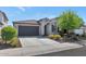 Charming single-story home with a tile roof, neutral stucco and a dark garage door at 22353 N 99Th Ln, Peoria, AZ 85383