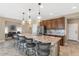 Open kitchen featuring granite countertops, a large island with pendant lighting, and stainless steel appliances at 22353 N 99Th Ln, Peoria, AZ 85383