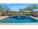 Sparkling pool with elegant waterfall surrounded by desert landscaping, offering a relaxing outdoor space at 22353 N 99Th Ln, Peoria, AZ 85383