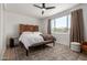Cozy bedroom with a wooden screen headboard, ceiling fan, and natural light at 22853 E Calle Luna --, Queen Creek, AZ 85142
