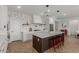 Modern open kitchen with stainless steel appliances, white cabinets, and center island with decorative pendant lights at 22853 E Calle Luna --, Queen Creek, AZ 85142