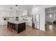 Spacious kitchen with an island, stainless steel refrigerator, and herringbone-patterned wood floors at 22853 E Calle Luna --, Queen Creek, AZ 85142
