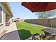 This landscaped back yard features green turf, desert landscaping, and comfortable patio seating at 24847 N 175Th Dr, Surprise, AZ 85387