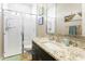 Modern bathroom featuring tiled shower, granite countertop, and a well-lit vanity at 24847 N 175Th Dr, Surprise, AZ 85387