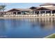 Beautiful lake view featuring a clubhouse with a patio and chairs with tables for entertaining at 24847 N 175Th Dr, Surprise, AZ 85387