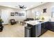 An open-concept living room showcases modern kitchen and comfortable sitting area with stylish furnishings at 24847 N 175Th Dr, Surprise, AZ 85387