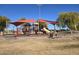 A modern playground featuring slides, climbing structures, and shaded seating areas for families at 24847 N 175Th Dr, Surprise, AZ 85387