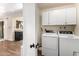 A brightly lit laundry area equipped with a washer, dryer and storage cabinets at 2843 E Captain Dreyfus Ave, Phoenix, AZ 85032