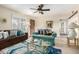 Bright living room with brown and blue couches, a modern ceiling fan, and neutral walls and flooring at 2843 E Captain Dreyfus Ave, Phoenix, AZ 85032