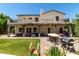 Expansive backyard with covered patio, outdoor kitchen, lush lawn, and upper-level balcony at 3229 E Mountain Village Cir, Phoenix, AZ 85042