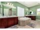 Bathroom featuring double vanity, tile floors, tile trimmed mirrors, and a large soaking tub with decorative tile surround at 3229 E Mountain Village Cir, Phoenix, AZ 85042