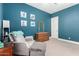 Bedroom featuring blue walls, carpet flooring, a comfortable reading chair, and a wooden dresser at 3229 E Mountain Village Cir, Phoenix, AZ 85042