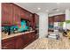 Granite countertops and stainless appliances shine in this kitchen with rich wood cabinetry at 3229 E Mountain Village Cir, Phoenix, AZ 85042