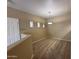 Hallway with neutral carpet and paint, coat hooks, small windows, and a modern light fixture at 3434 E Baseline Rd # 204, Phoenix, AZ 85042