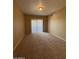 The carpeted living room has a sliding door and natural light at 3434 E Baseline Rd # 204, Phoenix, AZ 85042