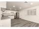 Bright kitchen features white cabinets, stainless steel appliances, and modern gray wood flooring at 3513 W Maryland Ave, Phoenix, AZ 85019