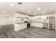 Bright kitchen with stainless steel appliances, white cabinets, granite countertops and hard surface floors at 3513 W Maryland Ave, Phoenix, AZ 85019