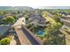 Aerial view of backyard pool oasis, desert landscaping, with tiled roof home in gated community, mountains in background at 3532 W Mesquite Ave, San Tan Valley, AZ 85144