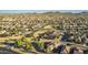 Aerial view showcases desert community, tile roof homes, and manicured landscaping, with mountain views at 3532 W Mesquite Ave, San Tan Valley, AZ 85144