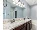 Bathroom with granite countertops, dual sinks, large mirror, white cabinets and combination tub/shower at 3532 W Mesquite Ave, San Tan Valley, AZ 85144