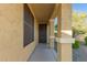 Covered entryway with a decorative dark wood front door and desert landscaping at 3532 W Mesquite Ave, San Tan Valley, AZ 85144
