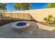 Outdoor fire pit with blue glass, surrounded by a decorative stone patio at 3532 W Mesquite Ave, San Tan Valley, AZ 85144