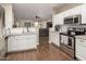Bright kitchen with granite countertops, stainless steel appliances, and wood flooring overlooking living room at 3532 W Mesquite Ave, San Tan Valley, AZ 85144