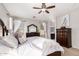 Bright main bedroom with large windows, carpet floors, ceiling fan, and matching dressers at 3532 W Mesquite Ave, San Tan Valley, AZ 85144
