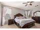 Spacious main bedroom with large windows, ceiling fan, and stylish dark wood furniture at 3532 W Mesquite Ave, San Tan Valley, AZ 85144