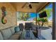 Inviting covered patio with outdoor seating, built in grill, tv, and lush landscaping at 3532 W Mesquite Ave, San Tan Valley, AZ 85144