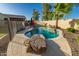 Gorgeous backyard pool area with rock features and outdoor seating under the covered patio at 3532 W Mesquite Ave, San Tan Valley, AZ 85144