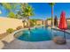 Sparkling pool with rock features and a safety fence in the backyard at 3532 W Mesquite Ave, San Tan Valley, AZ 85144