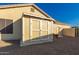 Tan backyard shed with double doors for storage, located next to home and gravel at 3532 W Mesquite Ave, San Tan Valley, AZ 85144