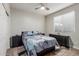 Cozy bedroom featuring a queen sized bed with floral bedding, dark furnishings and a ceiling fan at 4152 W Bradshaw Creek Ln, New River, AZ 85087